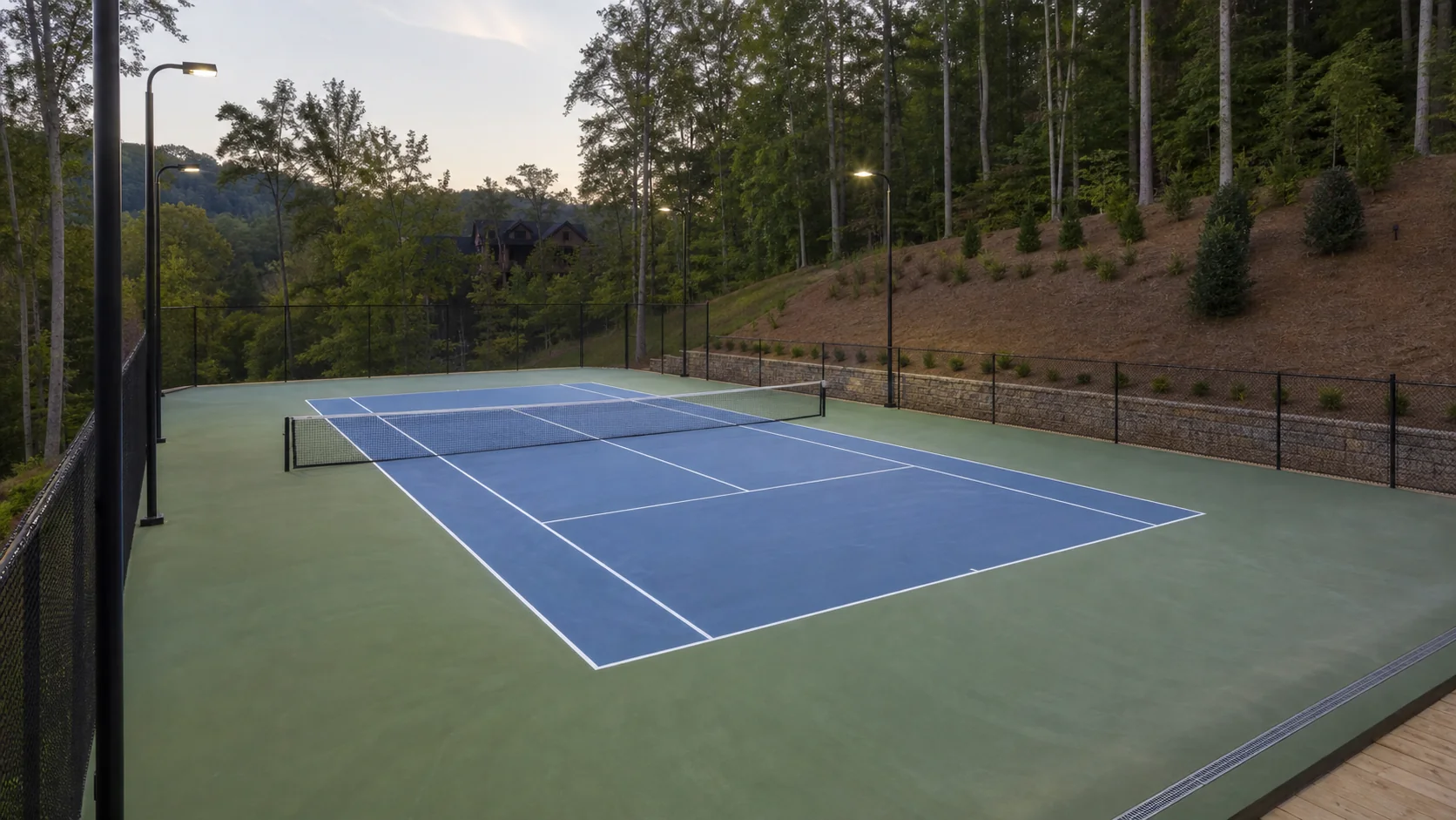 Private residential tennis or pickleball court integrated with the surrounding landscape